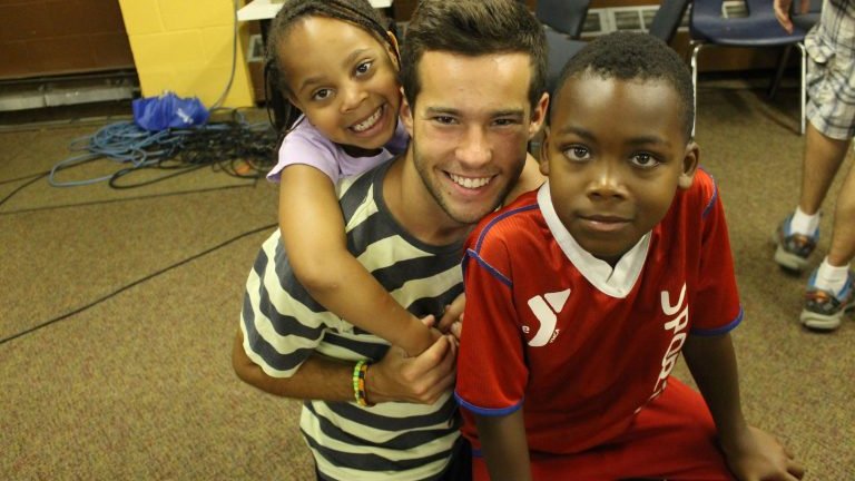 Camp volunteer with smiling kids
