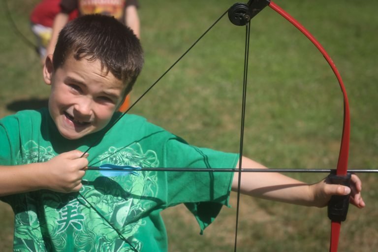Boy smiling with his bow and arrow