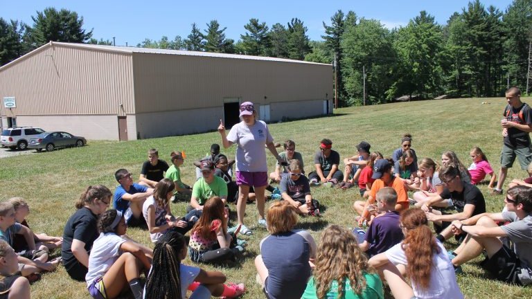 Camp staff member talking to a group of campers