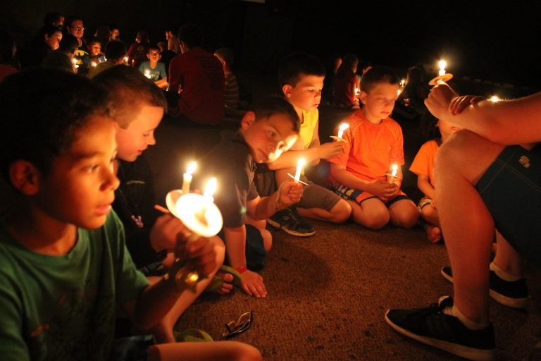 Boys holding candles at a special camp burton event